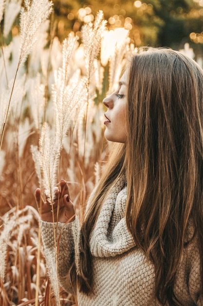 Frau, die zur Herbstzeit auf dem Feld steht.