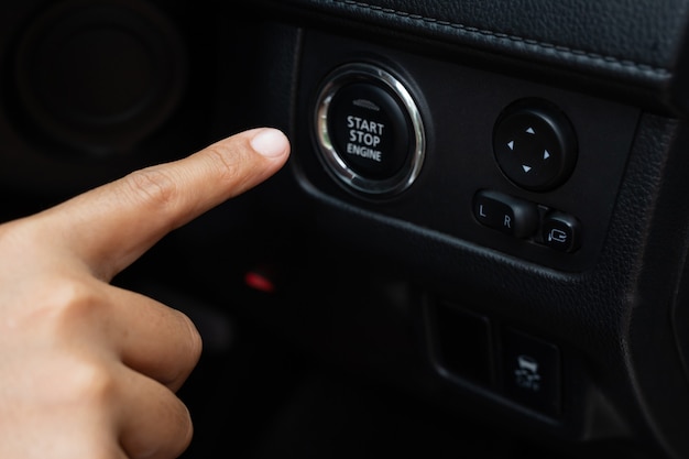 Frau drückt den Startknopf ihres Autos