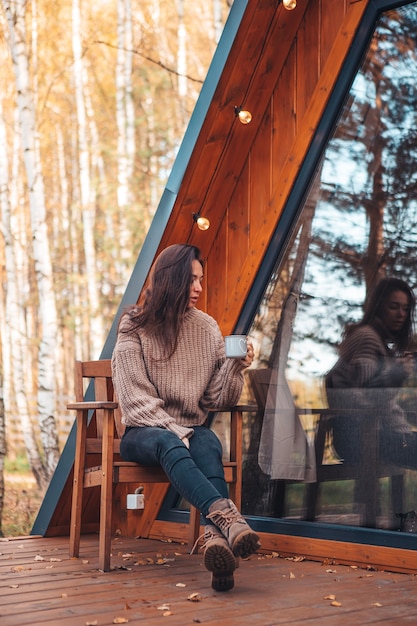 Frau entspannen im Freien im Herbsttag mit Tasse Kaffee