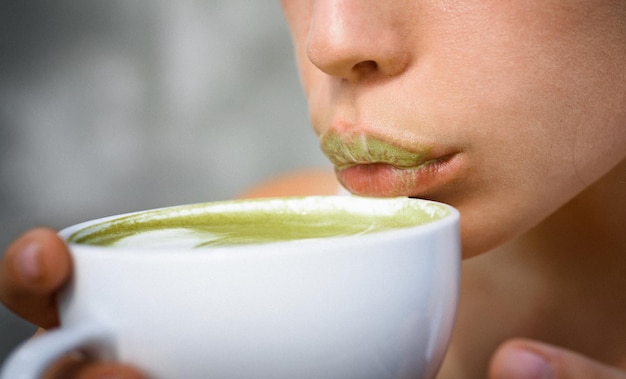 Frau entspannt sich im Café und trinkt. Perfekter Morgen mit grünem Kaffee. matcha latte teezeremonie des mädchens. Frau trinkt japanischen Tee aus der Tasse, sexy Lippen. Bester Tee überhaupt. Ihr perfektes Frühstück