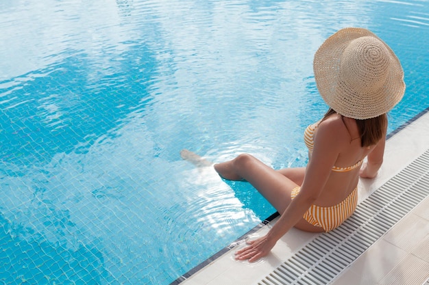 Frau entspannt sich im Sommerurlaub im Schwimmbad. Heißes, sonniges Urlaubskonzept mit Kopierraum