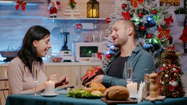 Frau erhält Geschenk vom Ehemann beim festlichen Abendessen