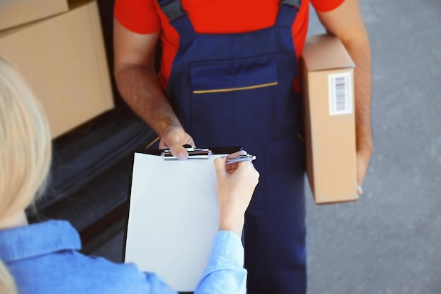 Foto frau erhält paket vom zusteller