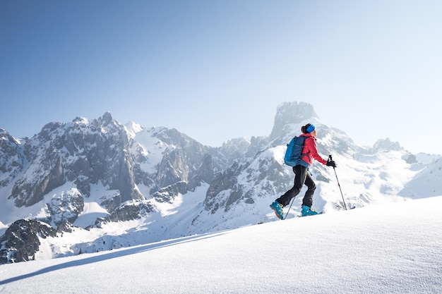 Frau fährt auf einem schneebedeckten Berg gegen den Himmel Ski