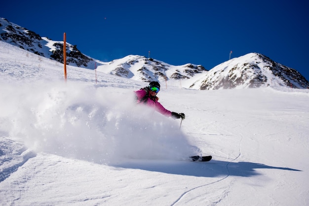 Frau fährt auf einem schneebedeckten Feld gegen einen klaren blauen Himmel Ski