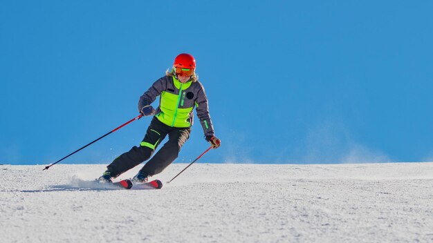 Frau fährt auf Schnee gegen den Himmel