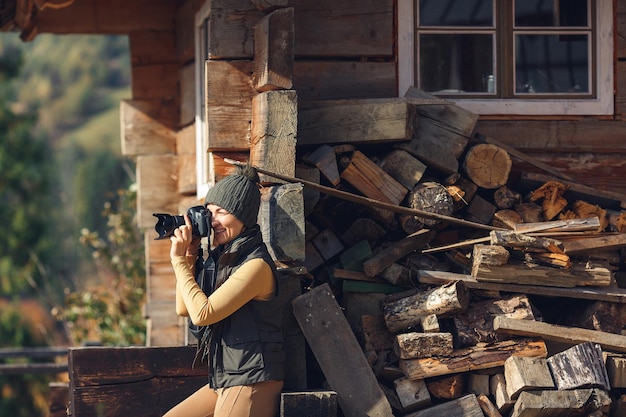 Frau fotografiert Herbstgebirgsnatur auf DSLR-Kamera.