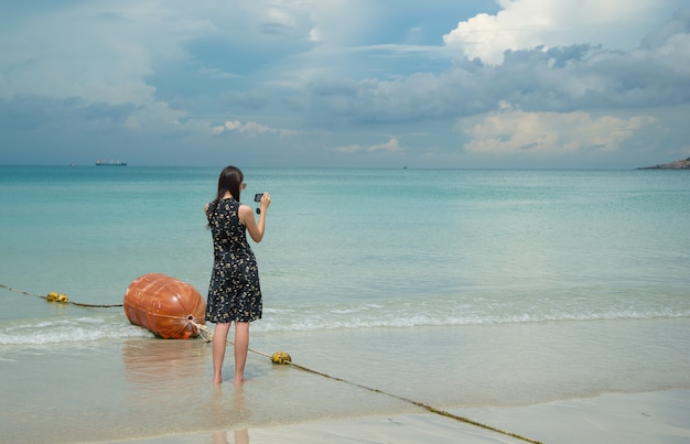 Foto frau fotografierte mit einem smartphone bei nam sai beach, chonburi, thailand