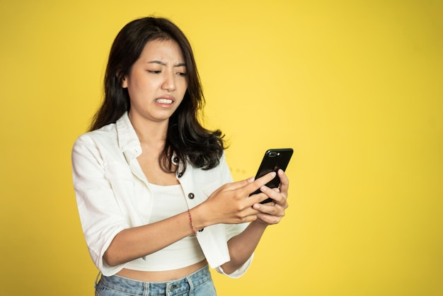 Frau fühlt sich angewidert und schockiert, wenn sie auf ihr Handy schaut