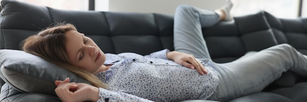 Frau fühlt sich müde und schläft zu Hause auf dem Sofa Faule Hausfrau entspannt sich auf der Couch