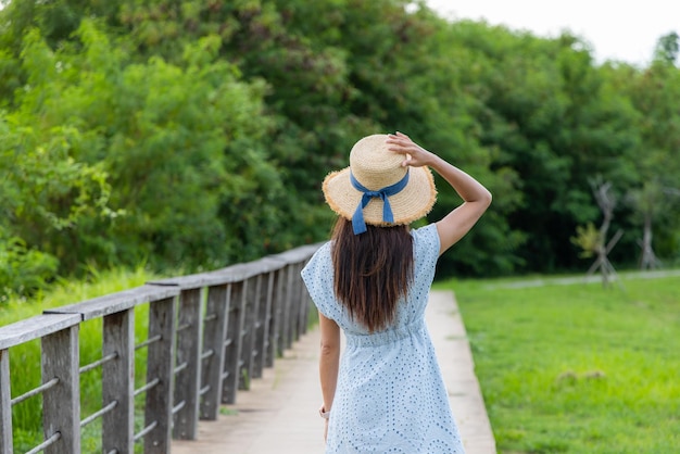 Frau geht auf einem Holzpfad im Park