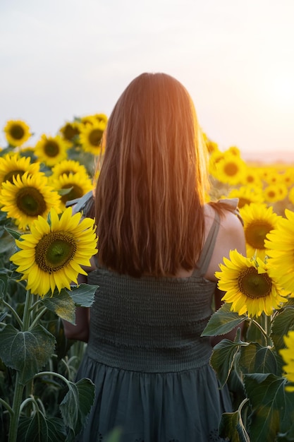 Frau geht durch Sonnenblumen und genießt lebendige Momente