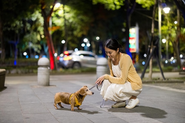 Frau geht nachts mit ihrem Hund spazieren