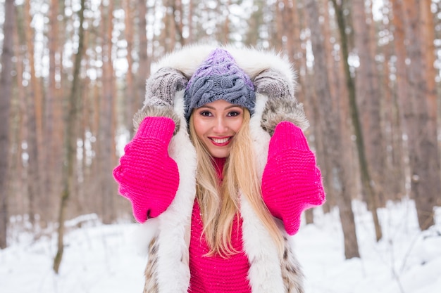 Frau gekleidet in Pelzweste über schneebedeckter Natur