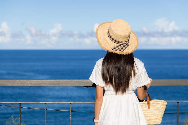 Frau genießt den Meerblick an einem sonnigen Tag