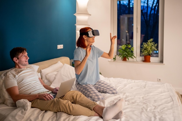 Frau genießt virtuelle Realität mit VR-Headset und lächelt bewundernd in Gesellschaft ihres Mannes
