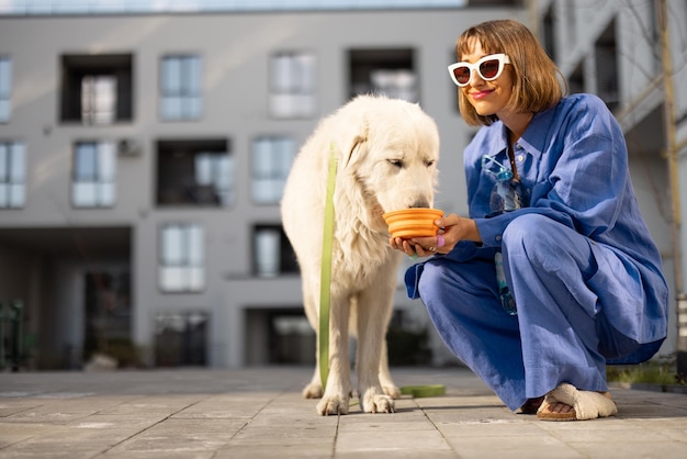 Frau gibt ihrem Hund Wasser