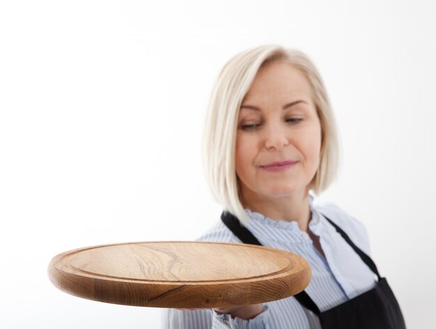 Frau gibt leeres Pizzaboard auf Weiß