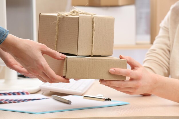 Frau gibt Paket in der Post