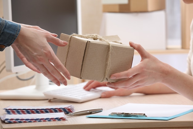 Frau gibt Paket in der Post