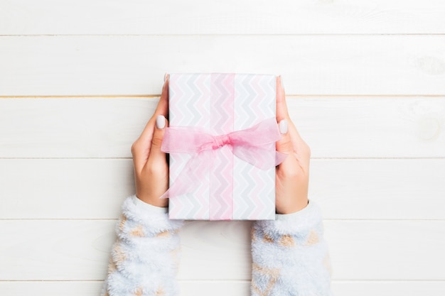 Frau gibt Valentinsgrußgeschenkbox mit rosa Bogen