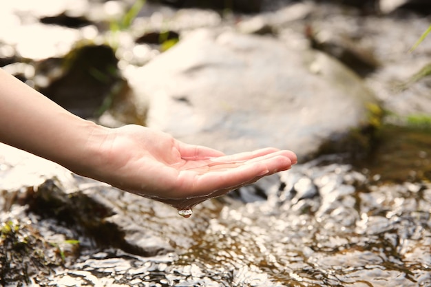 Frau gießt Wasser in die Hand