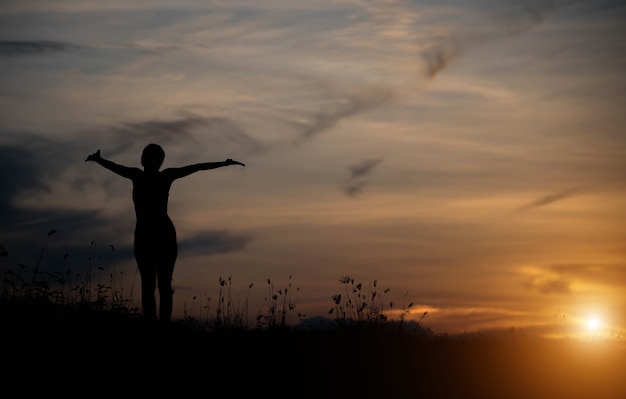 Frau glücklich bei Sonnenuntergang.