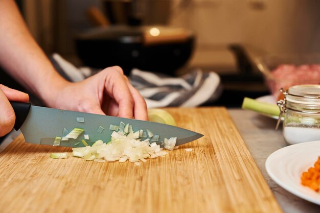 Frau hackt Zwiebel in der Küche hautnah