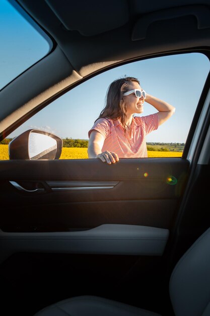 Frau hält an, um den Sonnenuntergang bei einem Roadtrip zu genießen