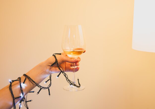 Foto frau hält das glas wein in händen weihnachtsbeleuchtung festliche zeit schönes foto