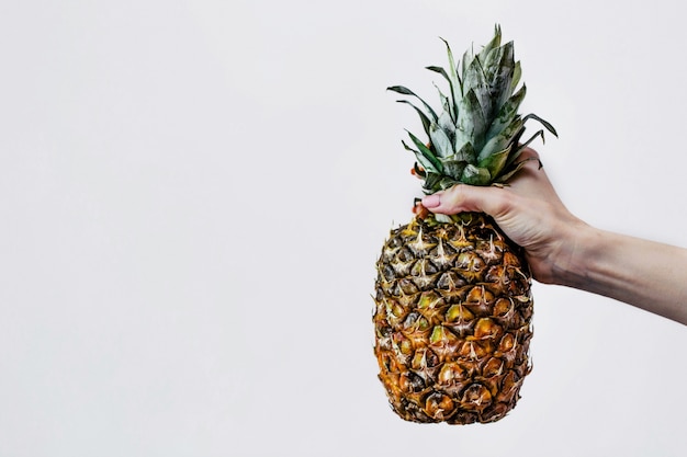 Frau hält eine Ananas in der Hand