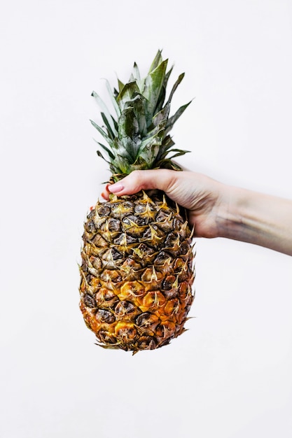 Frau hält eine Ananas in der Hand