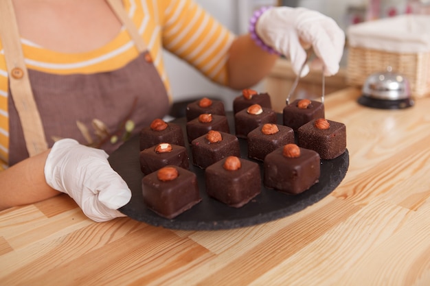 Frau hält einen Teller mit köstlichen rohen Desserts