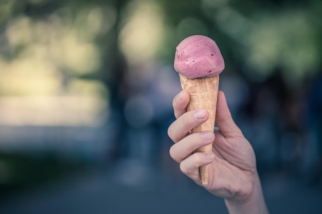 Frau hält Erdbeereis in ihrer Hand, schöner Sommertag