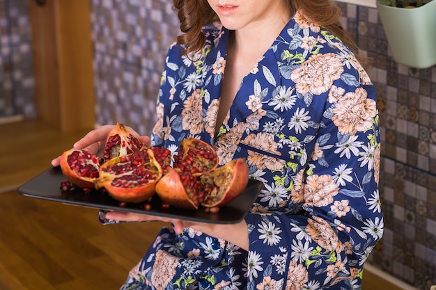 Frau hält frischen reifen Granatapfel. Obst, Vitamine und Lebensmittelkonzept. Nahansicht.