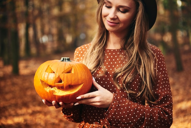 Frau hält gruseligen Kürbis für Halloween