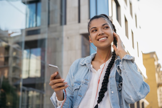 Frau hält Handy, das Musik hört