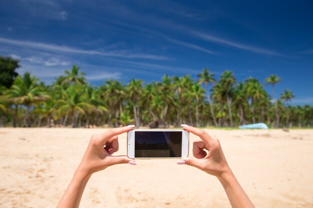 Foto frau hält handy mit schönem frischem meer