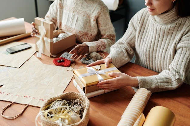 Frau hält ihre Hände auf einem Stapel Geschenke