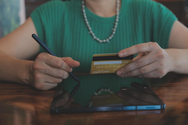 Frau hält Kreditkarte in der Hand und nutzt Laptop-Computer. Online-Shopping-Konzept aus nächster Nähe