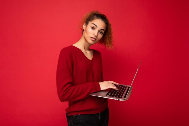 Frau hält Laptop-Computer beim Betrachten der Kamera-Eingabe