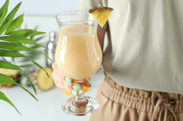 Frau hält Pina Colada Cocktail, Nahaufnahme.