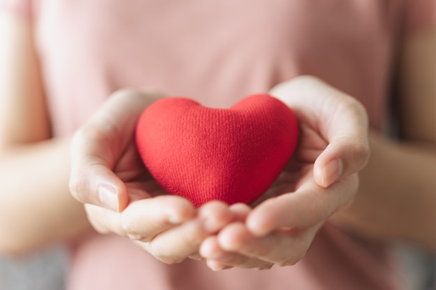 Frau hält rotes Herz Liebe Krankenversicherung Spende glücklich Wohltätigkeitsorganisation Freiwilliger Tag der psychischen Gesundheit