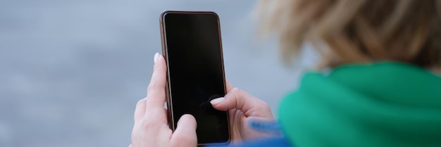 Frau hält Smartphone in den Händen auf Straßenmobil-App und Chat-Konzept