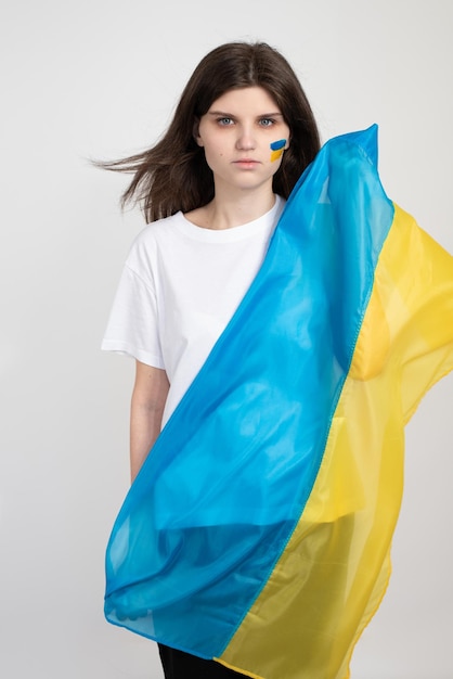 Frau hält ukrainische blaue und gelbe Flagge auf weißem Hintergrund Das Symbol der Unverletzlichkeit des ukrainischen Volkes Stoppt den Krieg in der Ukraine Russland stoppt den Krieg