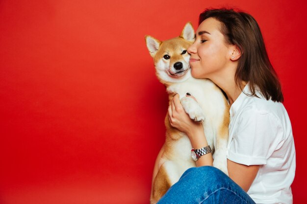 Foto frau hält und umarmt shiba inu hund