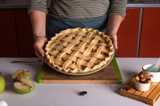 Frau hält und zeigt rohen Apfelkuchen, der bereit ist, in den Ofen gestellt zu werden Thanksgiving-Torte Vorbereitung Herbstbäckerei Knuspriges Wetter Süßigkeiten Rezept