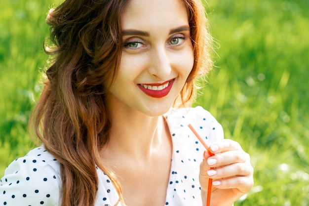 Frau hält Wassermelone auf Gras.