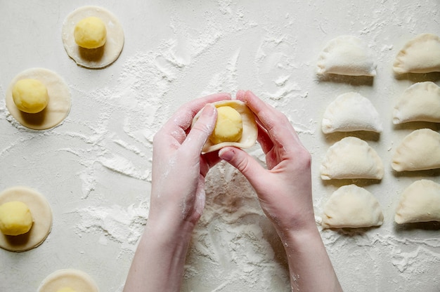 Frau Hände formt Knödel mit Kartoffeln. Traditionelles ukrainisches Essen