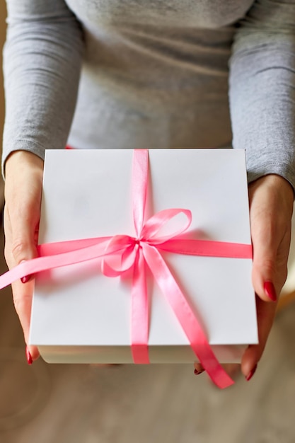 Frau Hände halten eine weiße Geschenkbox mit rosa Schleife Weibliche Hände halten Geschenkbox Weihnachten hew Jahr Geburtstag Valentine xAday Konzept Kopieren Sie Platz